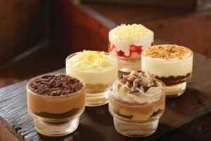 A selection of layered dessert cups with various creamy fillings and toppings