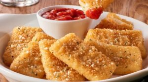 Crispy breaded appetizers served with a small bowl of marinara sauce.